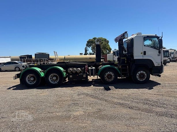 white and green hooklift truck